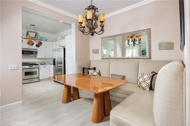 dining area with a chandelier, light wood-type flooring, and ornamental molding
