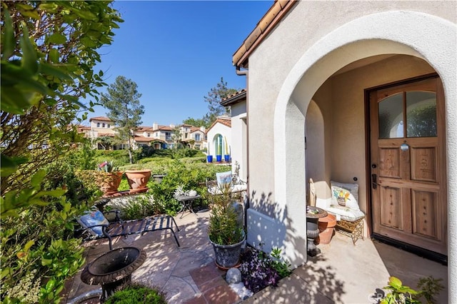 property entrance featuring stucco siding and a patio