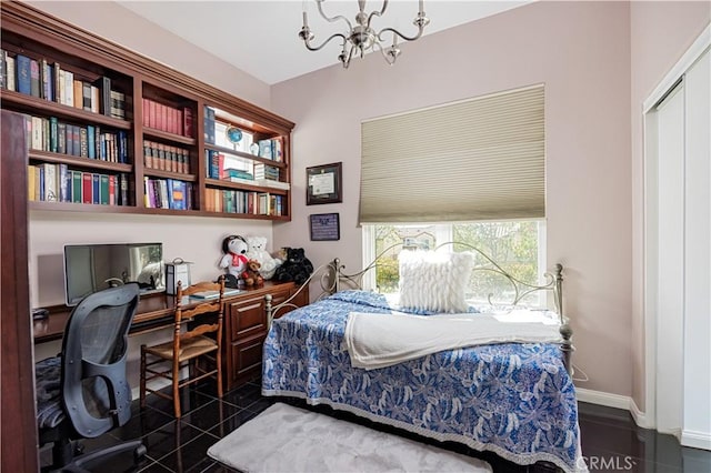 bedroom featuring a chandelier and baseboards