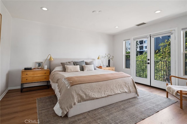 bedroom featuring access to exterior, wood finished floors, recessed lighting, and baseboards