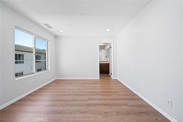 unfurnished room featuring light wood-style flooring, baseboards, and recessed lighting