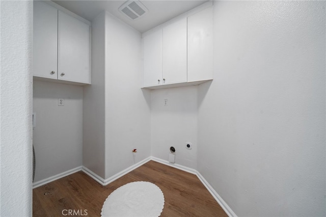 laundry room featuring dark wood-type flooring, cabinet space, electric dryer hookup, and baseboards