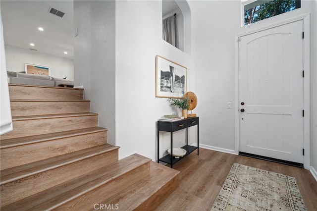 foyer with wood finished floors, stairs, recessed lighting, and baseboards