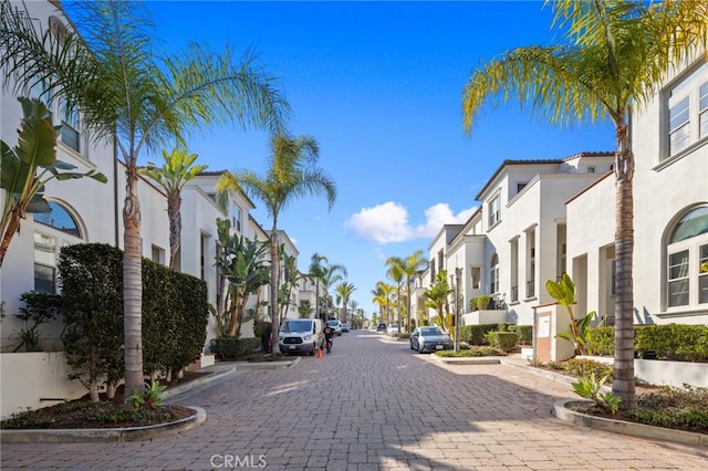 view of decorative road with a residential view and curbs