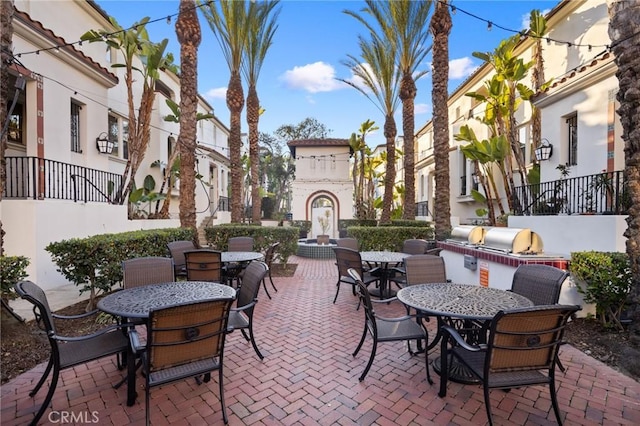 view of patio featuring outdoor dining area, an outdoor kitchen, and a fireplace