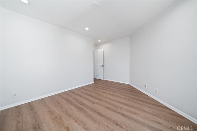 unfurnished room featuring recessed lighting, wood finished floors, and baseboards
