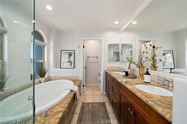 bathroom featuring toilet, a bath, double vanity, recessed lighting, and tile patterned floors