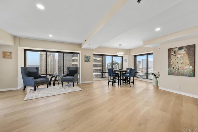 living area with baseboards, light wood-type flooring, and recessed lighting
