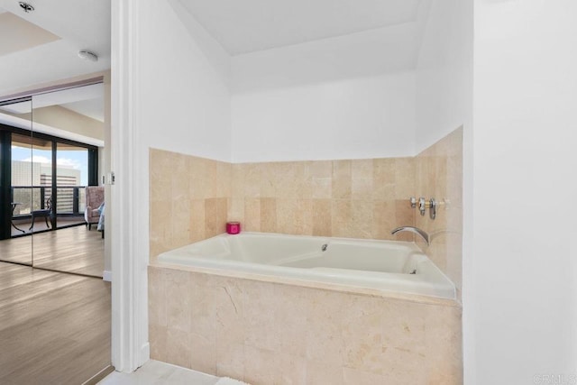 bathroom with a bath and wood finished floors
