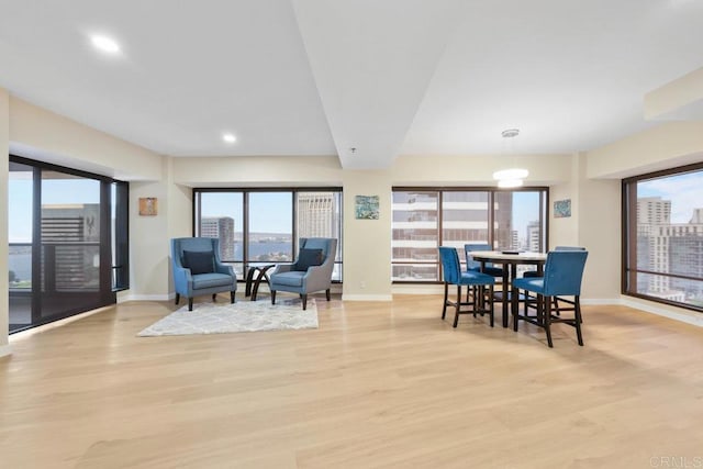 dining space featuring baseboards, light wood finished floors, and recessed lighting