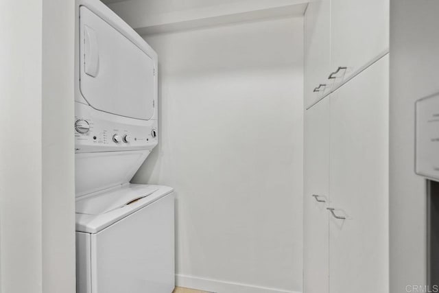 laundry area featuring stacked washer / drying machine