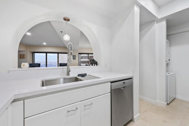 kitchen featuring dishwasher, washer and clothes dryer, a sink, white cabinets, and light countertops