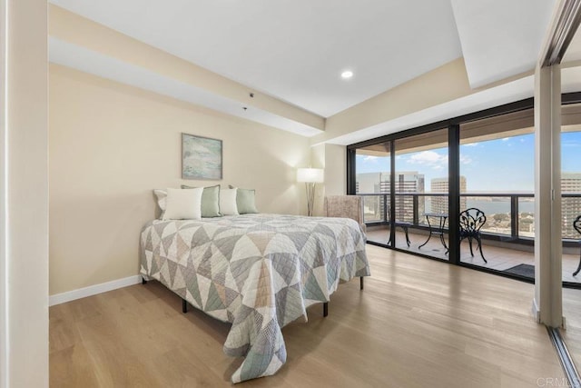 bedroom with access to exterior, wood finished floors, baseboards, and recessed lighting
