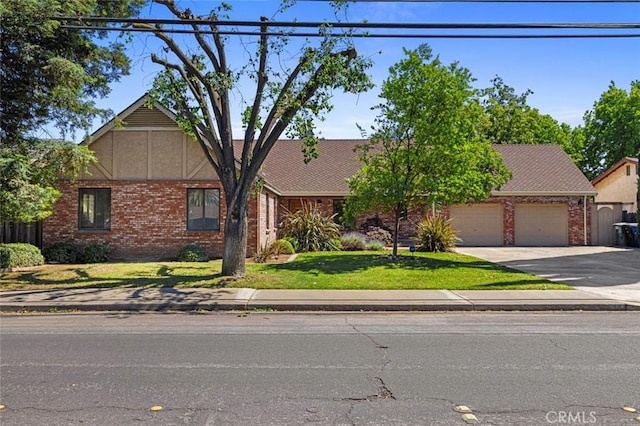 2604 Veneman Ave, Modesto, CA 95356 - view of front of house featuring an attached garage, brick siding, concrete driveway, and a front lawn