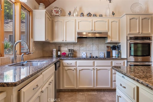2604 Veneman Ave, Modesto, CA 95356 - kitchen with under cabinet range hood, a sink, stainless steel appliances, tasteful backsplash, and light tile patterned flooring