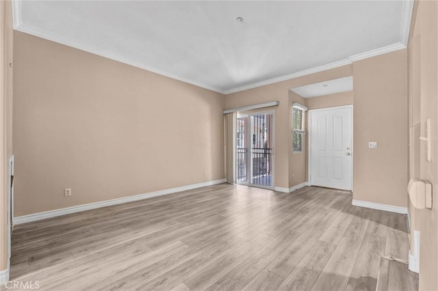 spare room with light wood-style flooring, baseboards, and ornamental molding