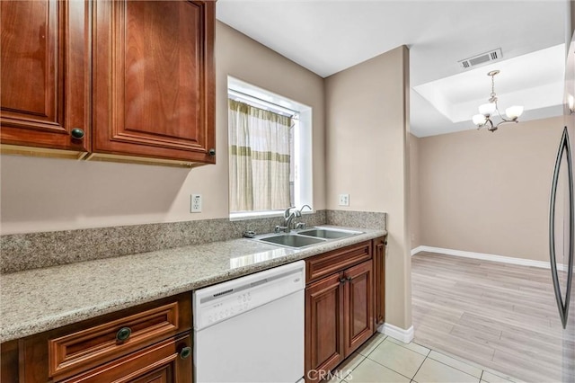 kitchen featuring dishwasher, a sink, baseboards, light tile patterned floors, and a chandelier