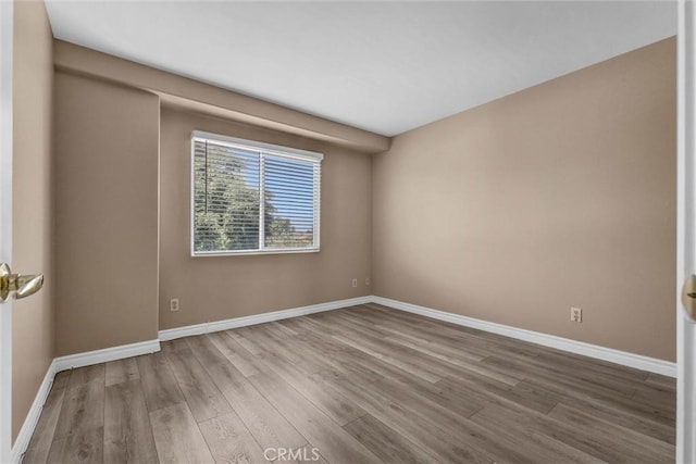 unfurnished room with wood finished floors and baseboards