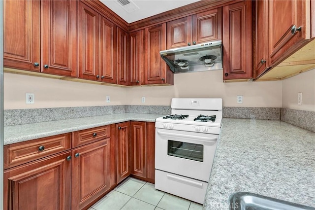 kitchen featuring white range with gas stovetop, under cabinet range hood, and light countertops