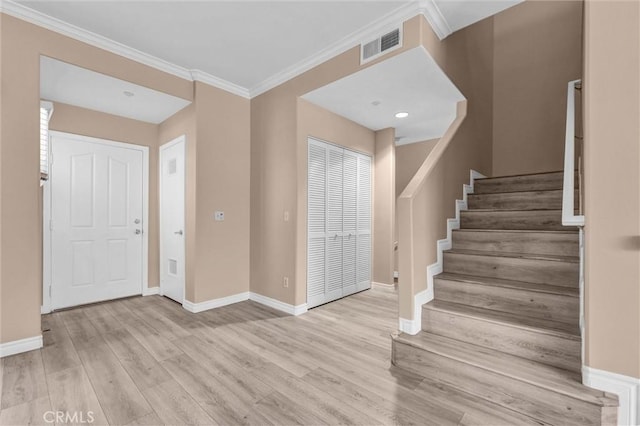 entryway featuring stairway, baseboards, wood finished floors, and crown molding