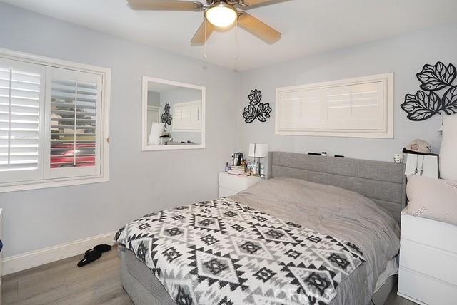 885 N Millard Ave, Rialto, CA 92376 - bedroom with wood finished floors, baseboards, and a ceiling fan