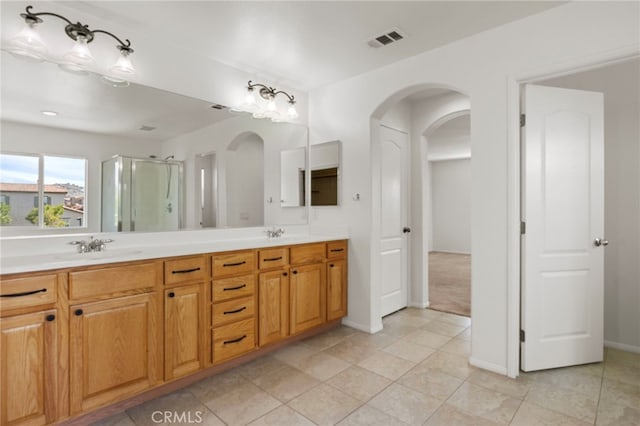 full bath featuring a shower stall, double vanity, baseboards, and tile patterned floors