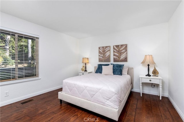 bedroom with hardwood / wood-style floors and baseboards