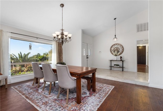 dining room with dark wood-style flooring, a chandelier, baseboards, and high vaulted ceiling