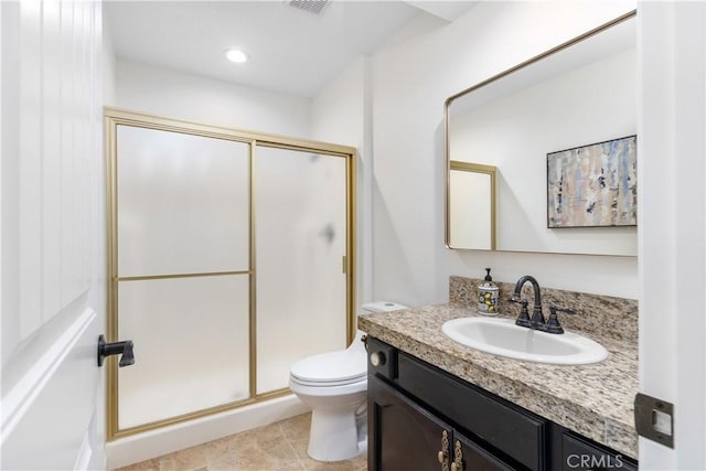 bathroom with a shower stall, toilet, and vanity
