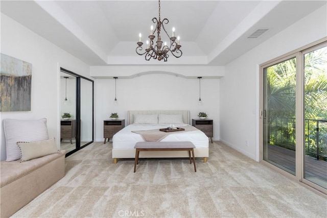 bedroom featuring access to outside, a tray ceiling, a chandelier, carpet, and baseboards