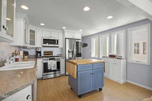 325 Ocean Dr, Oxnard, CA 93035 - kitchen with appliances with stainless steel finishes, butcher block countertops, a sink, white cabinetry, and blue cabinets