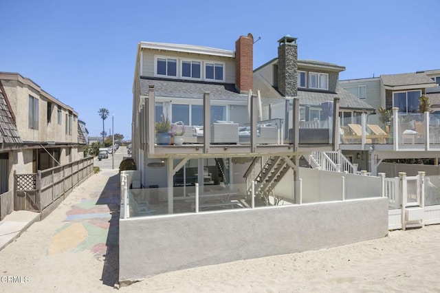325 Ocean Dr, Oxnard, CA 93035 - rear view of house with a chimney, a shingled roof, stairway, and fence