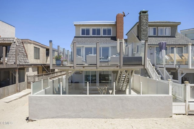 325 Ocean Dr, Oxnard, CA 93035 - back of property with a chimney, a shingled roof, stairway, and fence