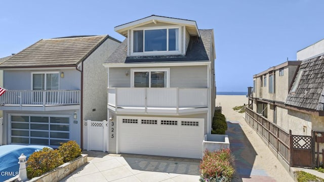 325 Ocean Dr, Oxnard, CA 93035 - view of front of property with a garage, concrete driveway, a balcony, and fence