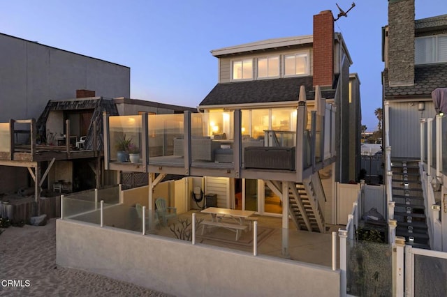 325 Ocean Dr, Oxnard, CA 93035 - back of property at dusk featuring stairs and a sunroom