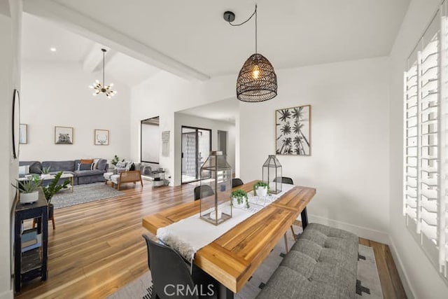 dining space featuring wood finished floors, a chandelier, healthy amount of natural light, and baseboards