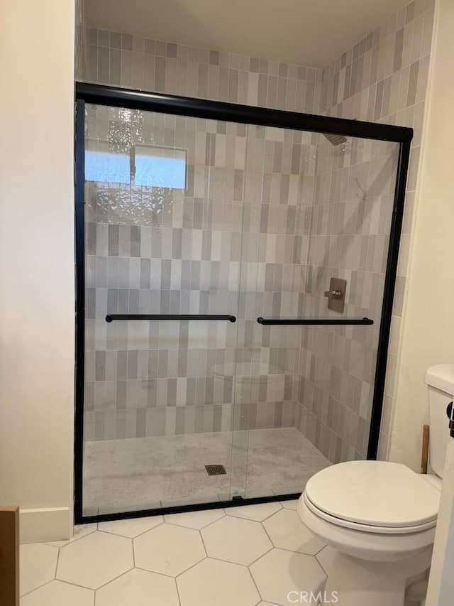 bathroom with toilet and a shower stall