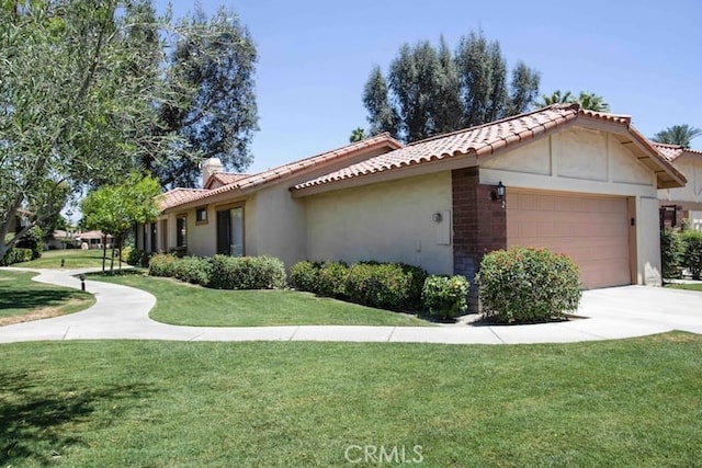 view of side of property with a tiled roof, a garage, a lawn, and stucco siding