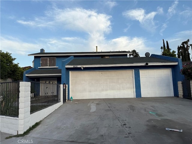 view of front of house with driveway, fence, a garage, and stucco siding