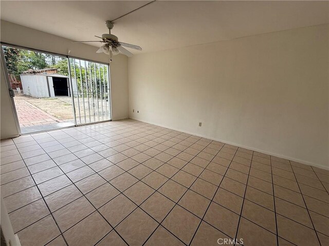 tiled spare room with ceiling fan