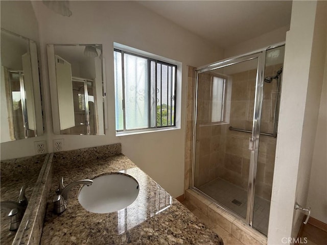 full bathroom with a shower stall and vanity