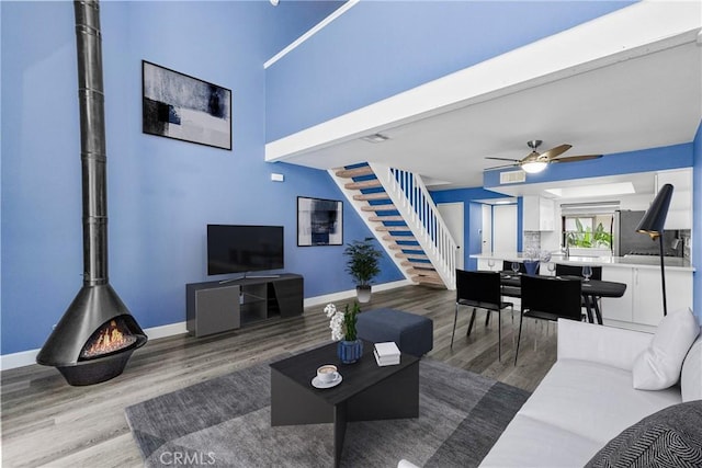 237 Oahu Way, Placentia, CA 92870 - living area with wood finished floors, stairway, a wood stove, and ceiling fan