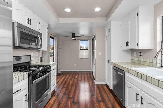 201 Lanai Ln, Placentia, CA 92870 - kitchen with appliances with stainless steel finishes, tile countertops, white cabinetry, a sink, and recessed lighting
