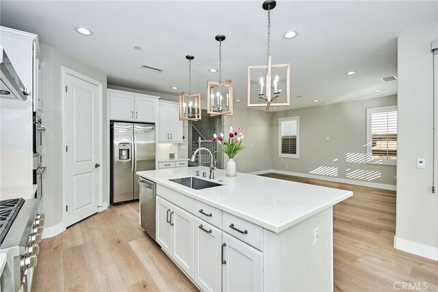 223 Gaspar, Irvine, CA 92618 - kitchen featuring stainless steel appliances, a sink, a chandelier, baseboards, and light wood-style flooring