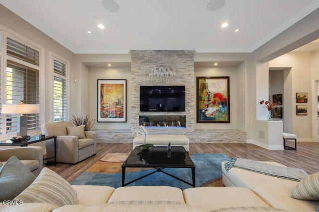 living area with wood finished floors, crown molding, baseboards, and recessed lighting