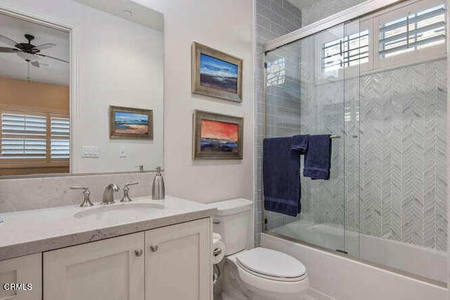 full bathroom with vanity, toilet, ceiling fan, and bath / shower combo with glass door