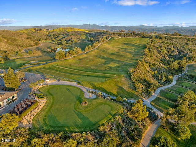 view of property location featuring a mountain backdrop and a golf course