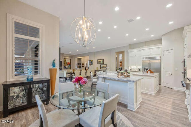 dining area featuring light wood-style floors, recessed lighting, a chandelier, and baseboards