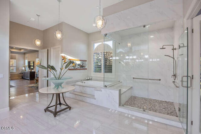 bathroom with a marble finish shower and a garden tub