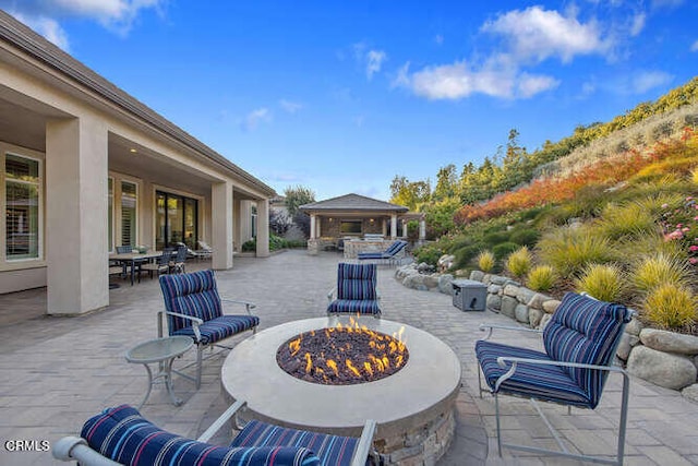 view of patio featuring an outdoor fire pit, a gazebo, and outdoor dining area